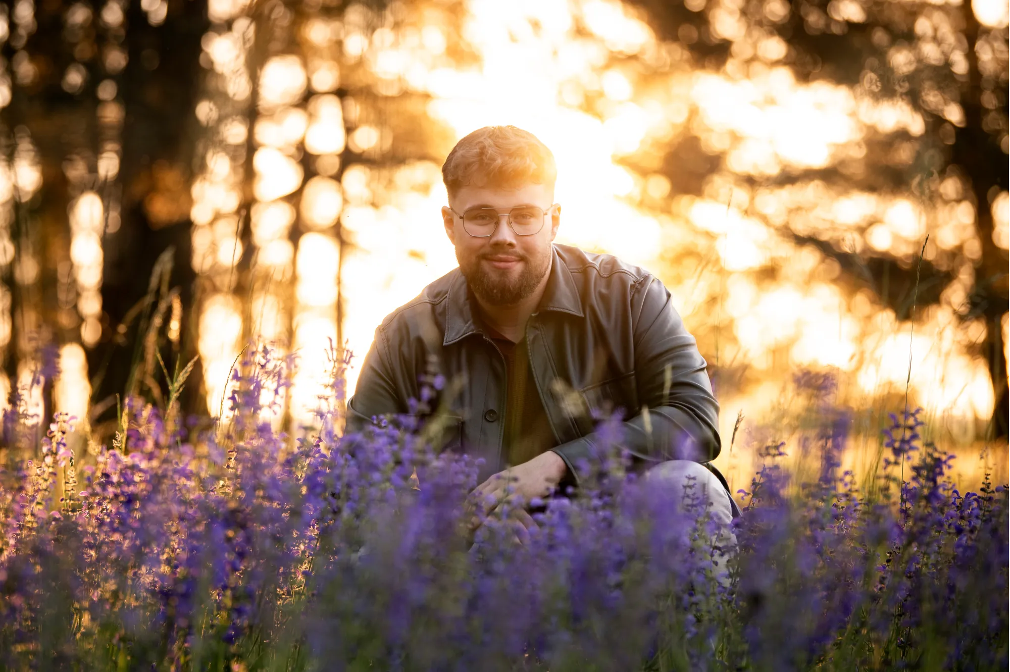 Fotografie von Inhaber Adrian Rauscher: In der Hocke in die Kamera schauend